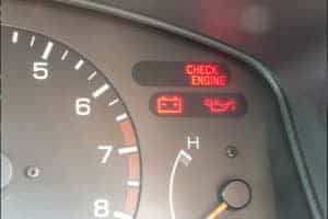Car dashboard showing check engine light on and other warning lights symbols